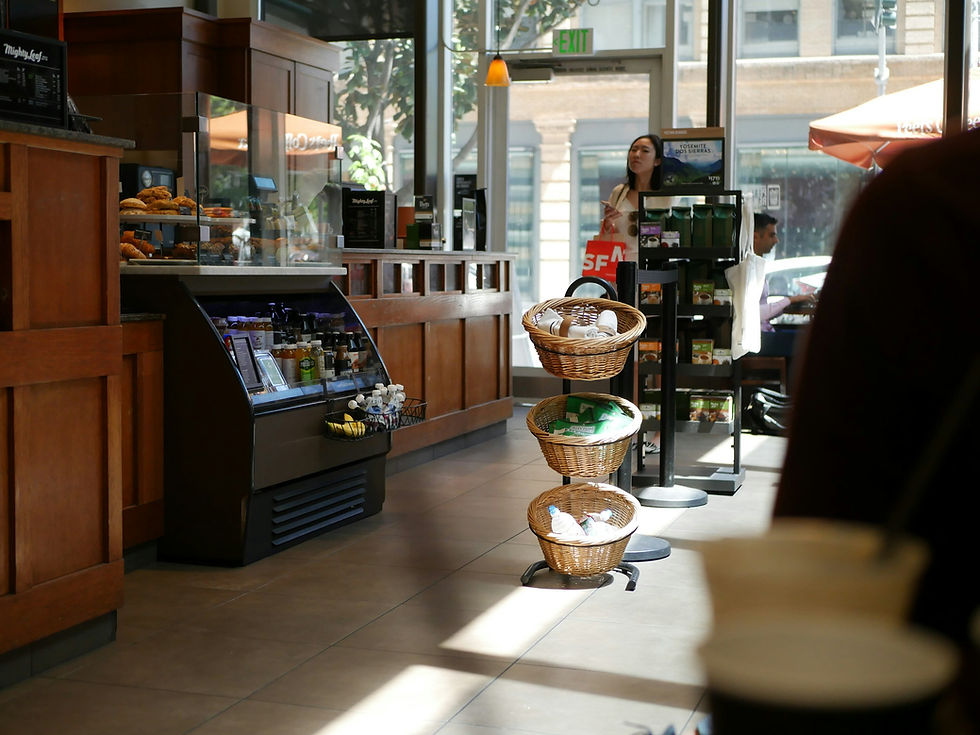Bright cafe interior with pastries, drinks, and customers