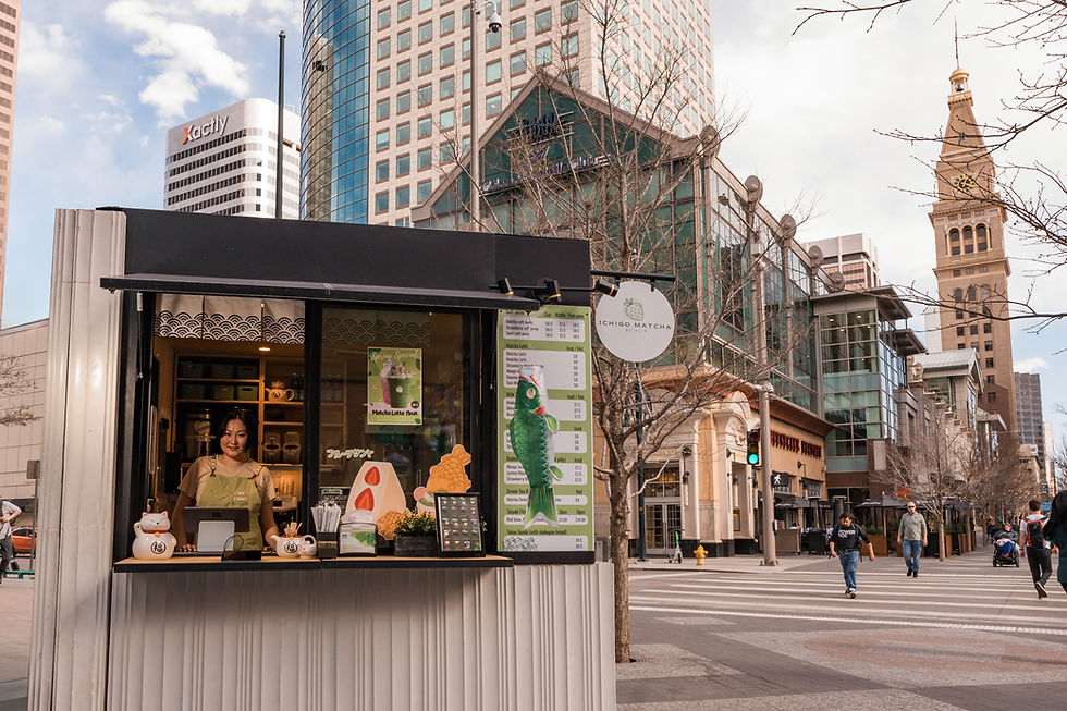 Smiling woman at Matcha Love tea kiosk in Denver