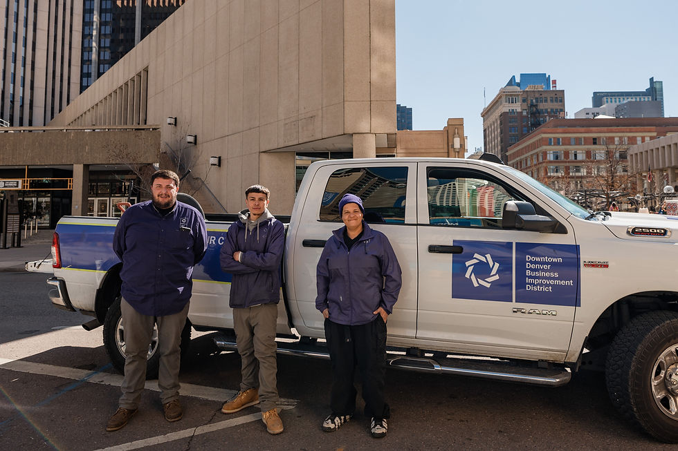 Three crew members stand proudly beside their company truck