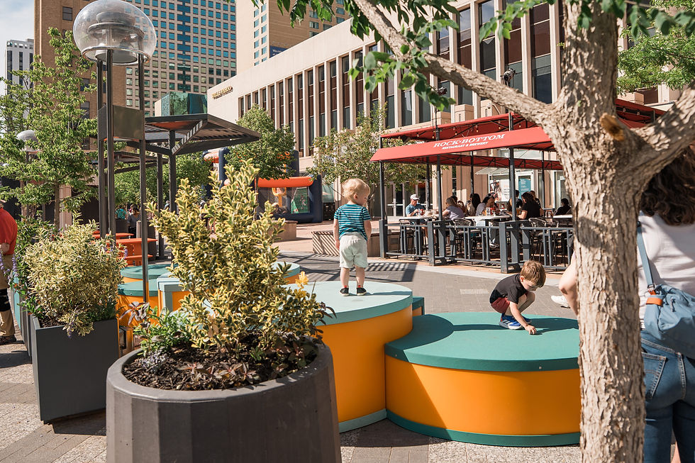Children playing near colorful urban seating and cafe