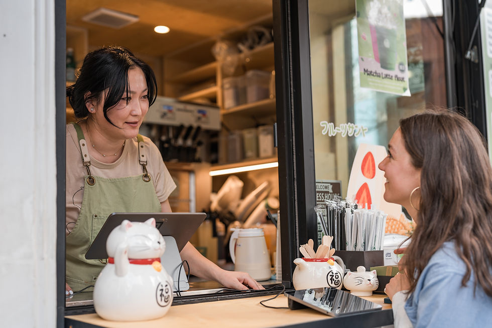 Barista assisting customer at cafe window